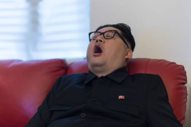 Пародист Ким Чен Ына, которого зовут Говард Икс, зевает на своем диване, одетый как лидер Северной Кореи, в своей студии в Гонконге. Фото: ANTHONY WALLACE/AFP via Getty Images) | Epoch Times Россия