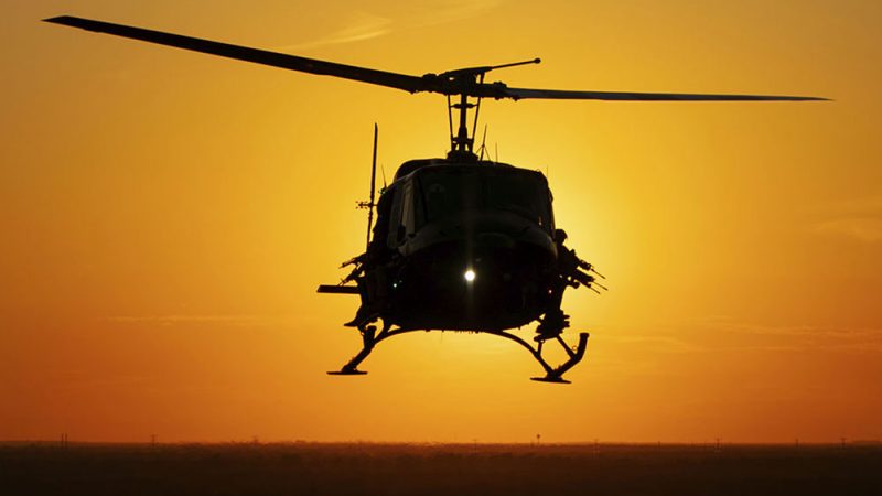 Артиллеристы наблюдают из дверей вертолёта Helibacon на закате. (HeliBacon) | Epoch Times Россия