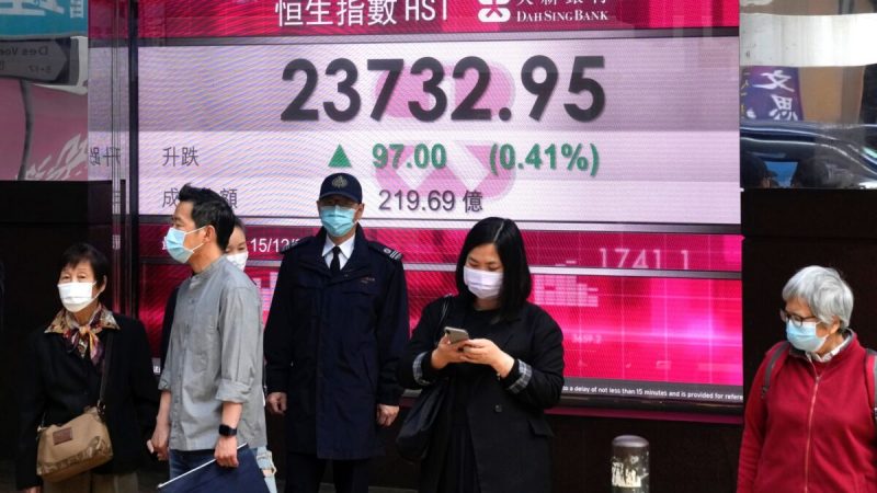 Люди следят за индексами акций на электронной панели банка в Гонконге, 15 декабря 2021 г. Фото: Kin Cheung/AP Photo
 | Epoch Times Россия