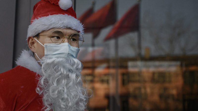 Китаец в костюме Санта-Клауса приветствует клиентов на рождественском мероприятии в торговом центре в Пекине 24 декабря 2020 г. Фото: Kevin Frayer, Getty Images
 | Epoch Times Россия