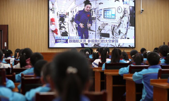  Учащиеся смотрят фильм о китайских астронавтах с китайской космической станции «Тяньгун» в рамках воспитания патриотизма, школа в Даньчжае, китайская провинция Гуйчжоу, 9 декабря 2021 года. (STR/AFP via Getty Images) | Epoch Times Россия