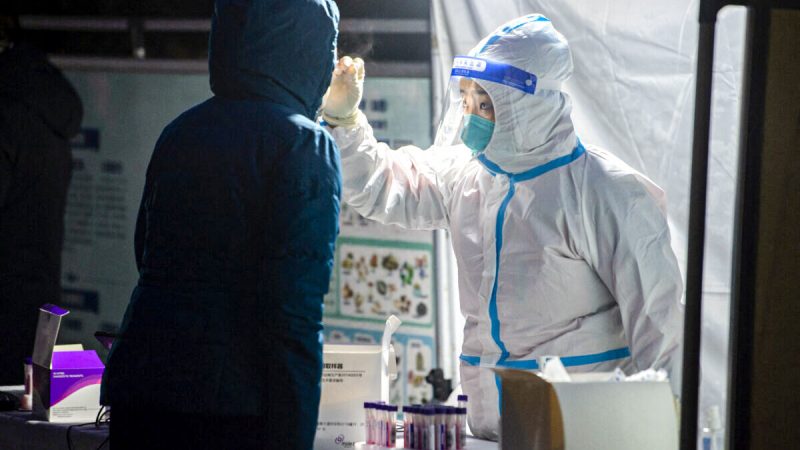 Медицинский работник берёт мазок у жителя для анализа на коронавирус COVID-19 в городе Сиань, провинция Шэньси, Китай, 25 декабря 2021 года. (STR/AFP via Getty Images) | Epoch Times Россия