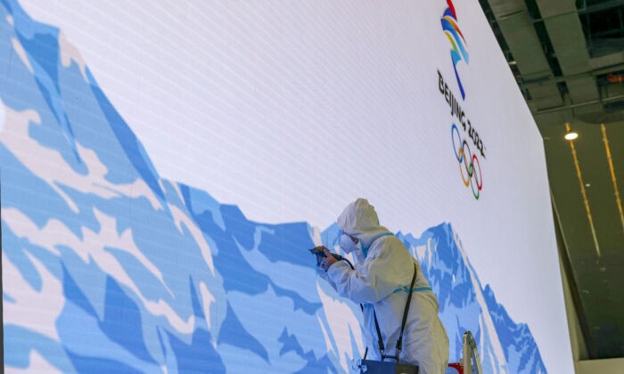 Рабочий ремонтирует видеостену в Главном медиацентре перед церемонией открытия зимних Олимпийских игр в феврале 9 января 2022 года в Пекине. (Katopodis/Getty Images | Epoch Times Россия