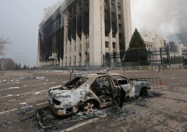 Сгоревший автомобиль стоит перед зданием мэрии, которое было сожжено во время протестов, вызванных повышением цен на топливо в Алма-Ате, Казахстан, 6 января 2022 года. (Pavel Mikheyev/Reuters)
