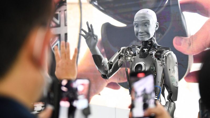 Посетители фотографируются и взаимодействуют с человекоподобным роботом с искусственным интеллектом Engineered Arts Ameca на выставке потребительской электроники (CES) в Лас-Вегасе, штат Невада, 5 января 2022 года. (Patrick T. Fallon/AFP via Getty Images) | Epoch Times Россия