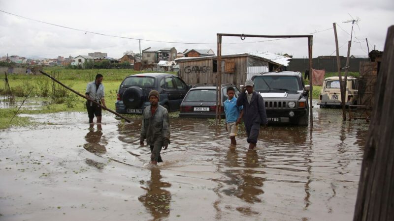 Рабочие пробираются через паводковые воды после сильного дождя в Антананариву, Мадагаскар, 19 января 2022 года. (Alexander Joe/AP Photo)  | Epoch Times Россия