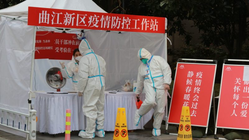 Государственные служащие в защитной одежде собираются на рабочем месте для борьбы с пандемией возле жилого квартала в городе Сиань на северо-западе Китая, провинция Шэньси, 3 января 2022 года. (Chinatopix Via AP) | Epoch Times Россия