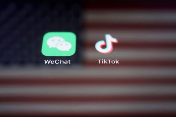 Отражение флага США на вывесках приложений WeChat и TikTok, 19 сентября 2020 г. (Florence Lo/Reuters)