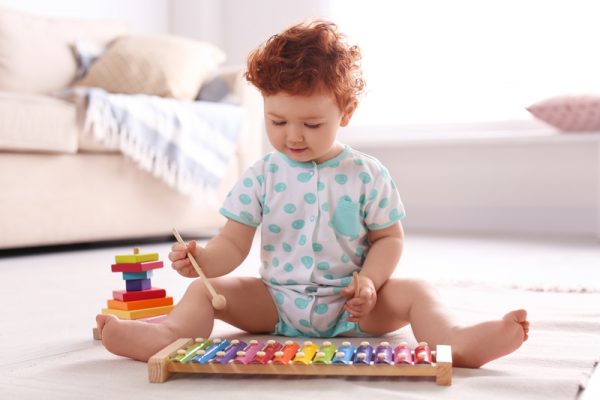 Чтобы приобрести сложные навыки, такие как речь, дети должны сначала развить основные сенсорные и моторные способности. (Image: Baby Xylophone via Dreamstime)