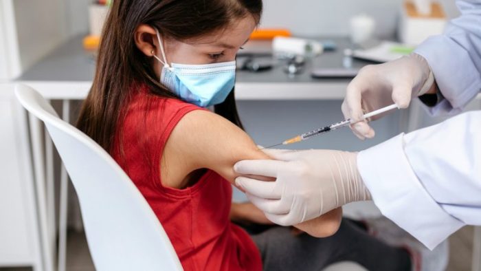 Девочке делают прививку против коронавируса. Её обязывают носить и маску. (iStock) | Epoch Times Россия