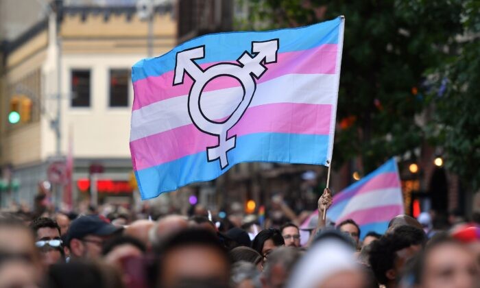 Человек с флагом трансгендеров. (Angela Weiss/AFP/Getty Images) | Epoch Times Россия