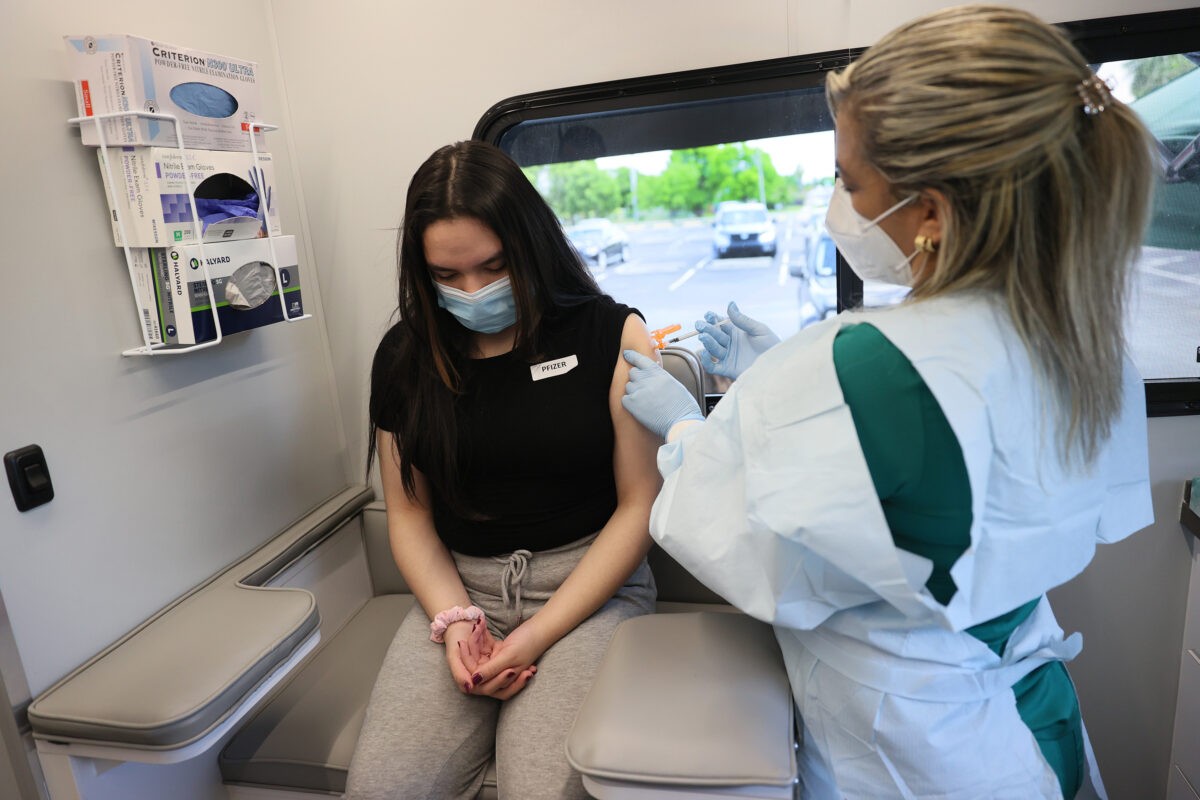 Женщина получает вакцину Pfizer-BioNTech COVID-19 в педиатрической мобильной клинике UHealth 17 мая 2021 года в Майами, штат Флорида. (Joe Raedle/Getty Images)
