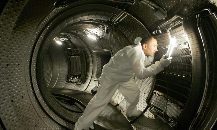 Техник проверяет систему нагрева плазмы внутри камеры ядерного реактора на этой фотографии из архива в Кадараше, Франция, 28 июля 2004 года. В типичных экспериментах по термоядерному синтезу используется реактор токамак, но метод Национального фонда зажигания с использованием мощных лазеров успешно производит чистую ядерную энергию. Фото: Boris Horvat/AFP/Getty Images | Epoch Times Россия