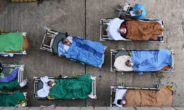 Пациенты лежат на больничных койках во временном изоляторе у медицинского центра «Каритас» в Гонконге, 16 февраля 2022 года. Фото: Sung Pi-Lung/The Epoch Times