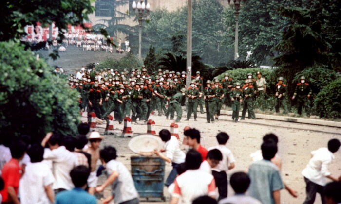 Китайские граждане и студенты в Чэнду, столице провинции Сычуань, бросают камни в солдат 4 июня 1989 года во время беспорядков, последовавших за объявлением военного положения в городе. Серия продемократических протестов была вызвана смертью 15 апреля бывшего лидера коммунистической партии Ху Яобана. В качестве демонстрации силы китайские лидеры выплеснули свою ярость на студентов-диссидентов и сторонников демократии. Фото: AFP / Getty Images | Epoch Times Россия