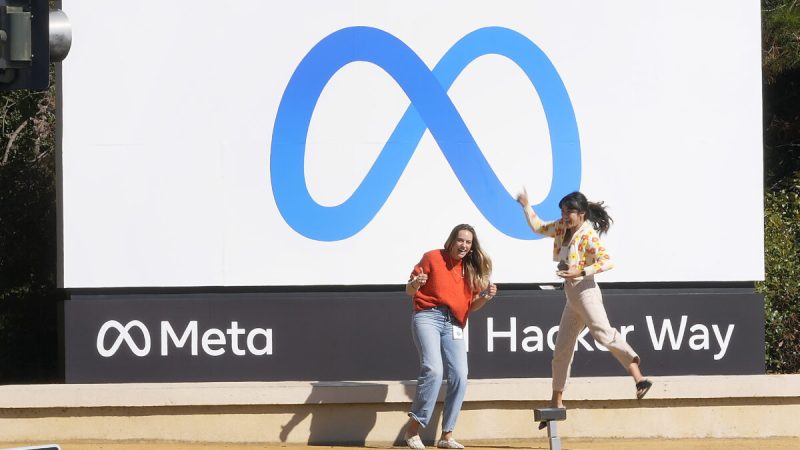 Сотрудники Facebook фотографируются на фоне нового названия и логотипа компании возле её штаб-квартиры в Менло-Парке, Калифорния, 28 октября 2021 года. Фото: Tony Avelar/AP Photo | Epoch Times Россия
