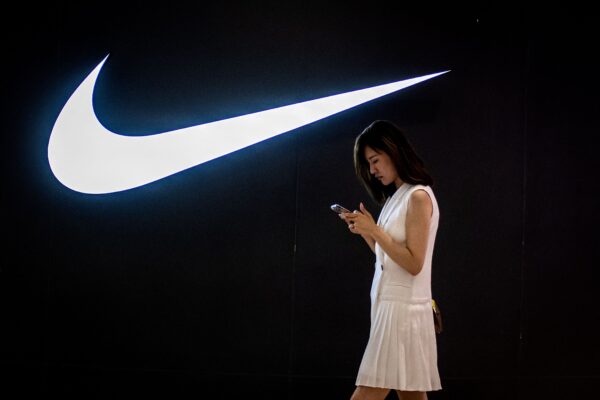 Женщина проходит мимо логотипа Nike в торговом центре в Пекине 2 июня 2021 года. (Nicolas Asfouri/AFP via Getty Images)