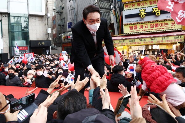 Юн Сук Ёль, кандидат в президенты Южной Кореи от основной оппозиционной Партии народной власти, пожимает руки своим сторонникам во время предвыборной кампании в Сеуле, Южная Корея, 1 марта 2022 года. (KimHong-Ji/Reuters)