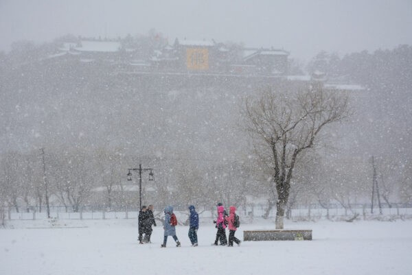 Люди посещают парк Бэйшань во время снегопада в городе Цзилинь в северо-восточной китайской провинции Цзилинь 13 марта 2019 года. Фото: STR/AFP viaGettyImages