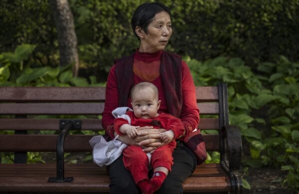 Женщина держит на руках ребёнка в парке в Пекине 12 мая 2021 года. (KevinFrayer/GettyImages)