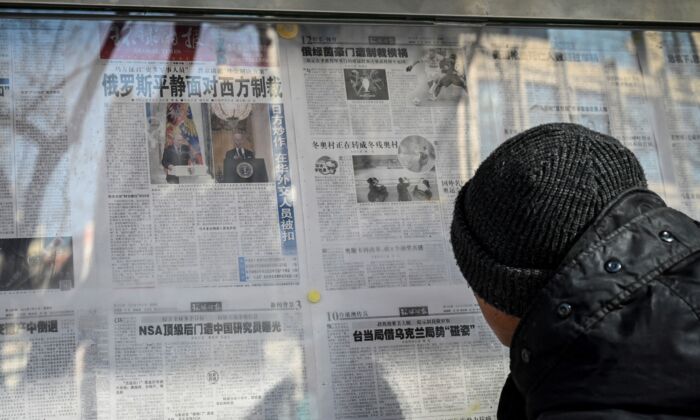 Мужчина читает китайскую государственную газету, освещающую конфликт между Россией и Украиной, на улице в Пекине, Китай, 24 февраля 2022 года. Фото: Jade Gao/AFP via Getty Images
 | Epoch Times Россия