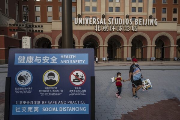На табличке указаны меры по борьбе с эпидемией COVID-19 у входа в Universal Studios Beijing в Пекине, Китай, 23 сентября 2021 года. Фото: Kevin Frayer/Getty Images