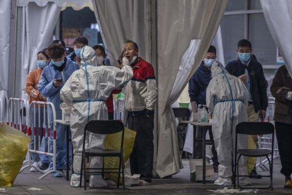 Медицинский работник надевает защитную одежду на пункте массового тестирования в Пекине, Китай, 15 марта 2022 года. Фото: KevinFrayer/GettyImages