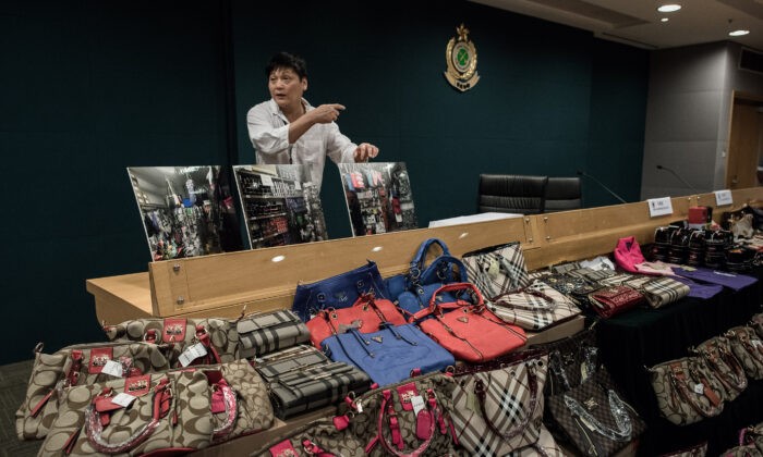 Поддельные предметы роскоши демонстрируются во время пресс-конференции после рекордной конфискации в штаб-квартире таможни в Гонконге 6 августа 2015 г. Фото: Philippe Lopez/AFP via Getty Images
 | Epoch Times Россия