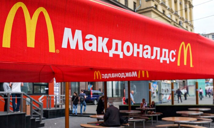 Люди сидят на террасе закрытого ресторана McDonald’s в Москве, 21 августа 2014 года. Фото: AlexanderNemenov/AFPviaGettyImages
 | Epoch Times Россия