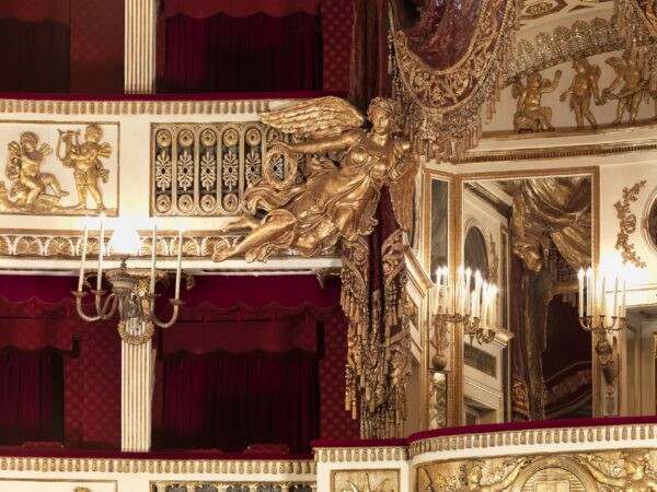 Ангелы с венками парят и придерживают открытую драпировку, чтобы показать тех, кто находится в королевской ложе зевакам в зрительном зале. (Luciano Romano/Teatro di San Carlo)