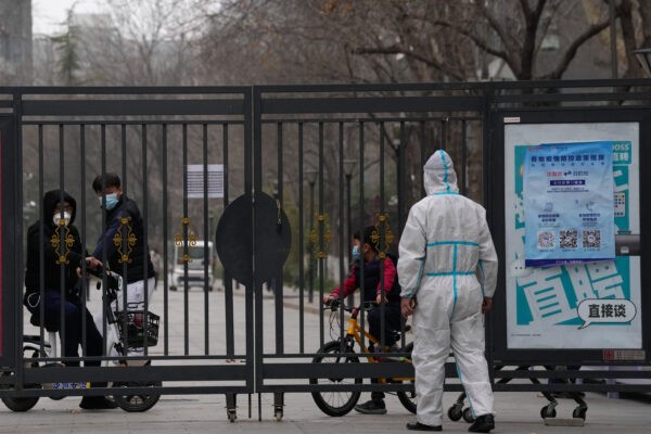 Жители закрытого района за воротами, 13 марта 2022 года в Пекине. Фото: Ng Han Guan/AP Photo