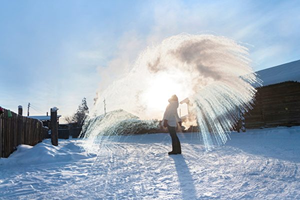 Республика Саха — самое холодное место из всех обитаемых территорий в мире. На снимке местная жительница разбрызгивает в воздухе горячую воду — и вода быстро замерзает. Выглядит красиво, подобно фейерверку (изображение: Shutterstock) | Epoch Times Россия
