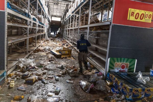 Сотрудник полицейской службы ЮАР ищет мародёров внутри торгового центра Gold Spot в Вослорусе, к юго-востоку от Йоханнесбурга, 12 июля 2021 года. (Guillem Sartorio/AFP via Getty Images)