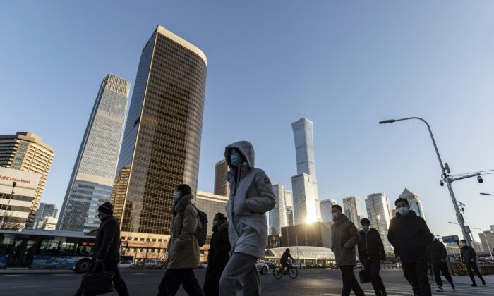 Пешеходы переходят дорогу перед зданиями в центральном деловом районе Пекина, Китай, 23 ноября 2021 года. (Qilai Shen/Bloomberg via Getty Images) | Epoch Times Россия
