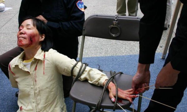 Воссоздание одного из методов пыток, применяемых китайскими чиновниками для принуждения последователей Фалуньгун к отказу от их веры.
(Minghui.org)