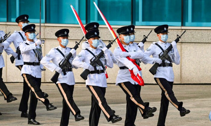 Полицейские идут с флагами Китая и Гонконга во время церемонии поднятия флага в честь 24-й годовщины передачи Гонконга от Великобритании. Гонконг 1 июля 2021 года. (PeterParks/AFP viaGettyImages)
 | Epoch Times Россия