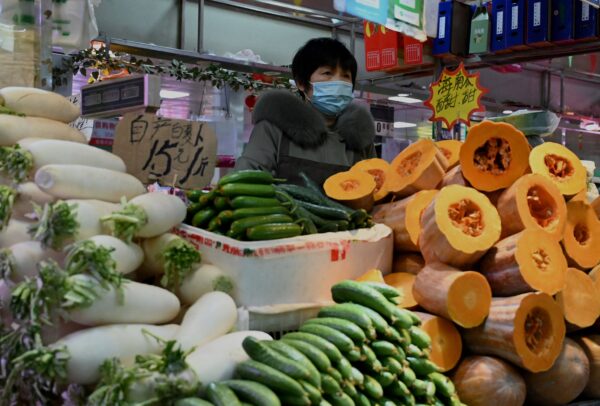 Продавец овощей на рынке в Пекине. 17 января 2022 года. (Noel Celis/AFP via Getty Images)