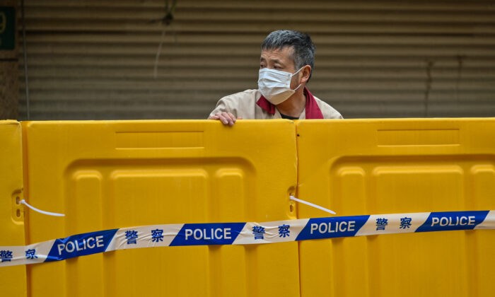 Мужчина стоит за барьерами во время блокировки в районе Цзинъань, Шанхай, 31 марта 2022 года. (Hector Retamal/AFP via Getty Images) | Epoch Times Россия