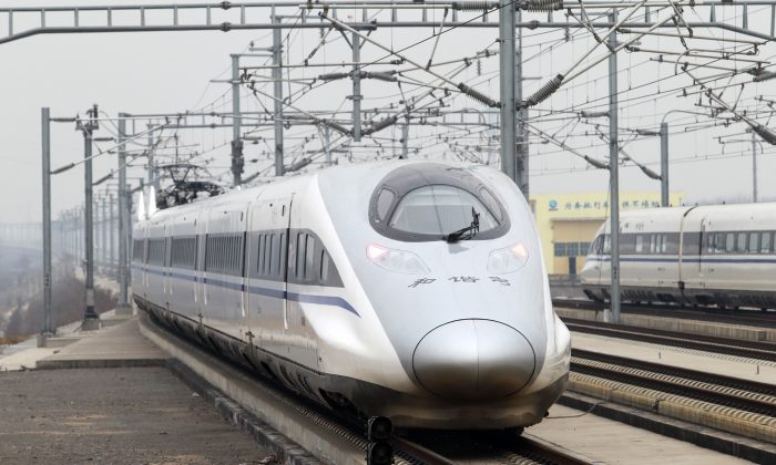 Высокоскоростной поезд, курсирующий по новой линии протяжённостью 2298 км между Пекином и Гуанчжоу, въезжает на Восточный вокзал Сючан, Сючан, центральная китайская провинция Хэнань, 26 декабря 2012 года. (STR/AFP/Getty Images) | Epoch Times Россия