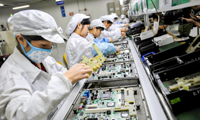 Китайские рабочие собирают электронные компоненты на заводе тайваньского технологического гиганта Foxconn в городе Шэньчжэне, провинция Гуандун, Китай, 26 мая 2010 года. (AFP/AFP/Getty Images) | Epoch Times Россия
