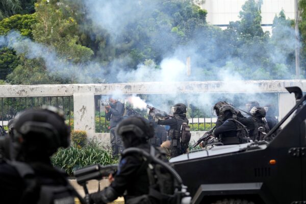 Полиция пускает слезоточивый газ, чтобы разогнать демонстрантов во время митинга в Джакарте, Индонезия, 11 апреля 2022 года. Фото: Tatan Syuflana/AP Photo