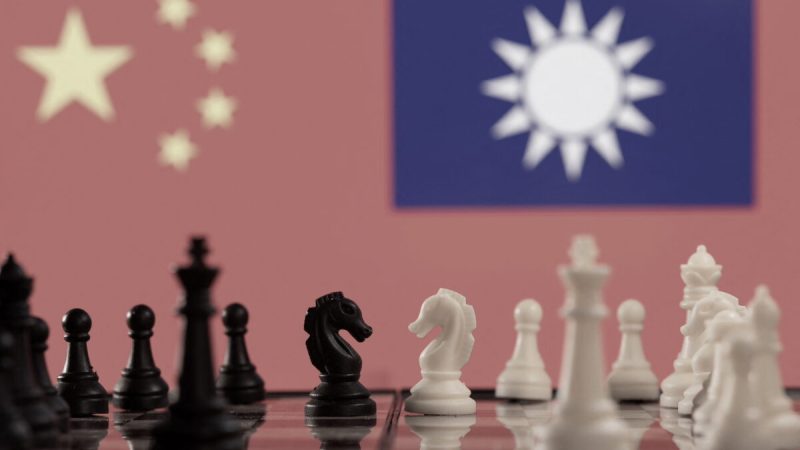 Шахматные фигуры перед развевающимися флагами Китая и Тайваня. Фото: Reuters/Dado Ruvic/Illustration | Epoch Times Россия