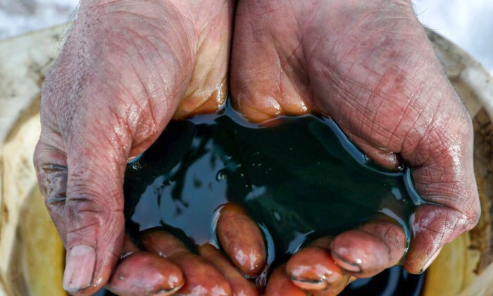 Работник держит образец сырой нефти на Ярактинском месторождении, принадлежащем Иркутской нефтяной компании, в Иркутской области России 11 марта 2019 года. (Vasily Fedosenko/Reuters) | Epoch Times Россия