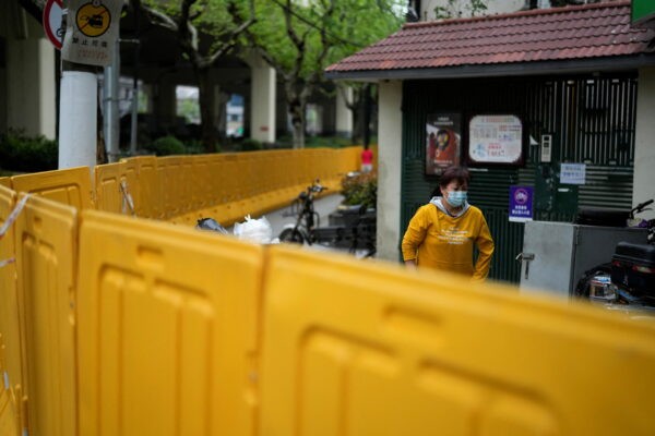 Житель за барьерами, ограждающими закрытый район в Шанхае 14 апреля 2022 года. (Aly Song/Reuters)