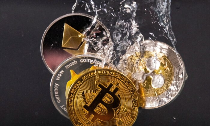 Сувенирные жетоны, представляющие криптовалютные сети Bitcoin, Ethereum, Dogecoin и Ripple, погружаются в воду 17 мая 2022 года. Фото: Dado Ruvic/Illustration/Reuters | Epoch Times Россия