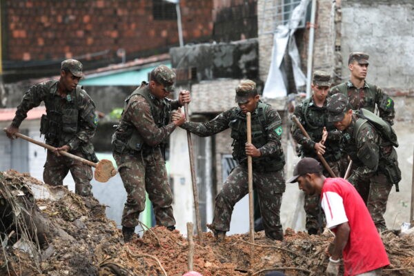Армейские офицеры работают на месте обрушения дома в результате схода оползня, вызванного проливными дождями в Жардим Монте Верде, в районе Ибура, в Ресифи, Бразилия, 29 мая 2022 года. (Diego Nigro/Reuters)