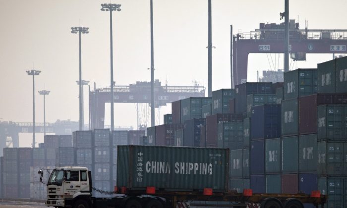 Грузовик перевозит контейнер для погрузки на корабль в порту Тяньцзиня, Китай, октябрь 2017 года. (Alexander F. Yuan/AP Photo) | Epoch Times Россия
