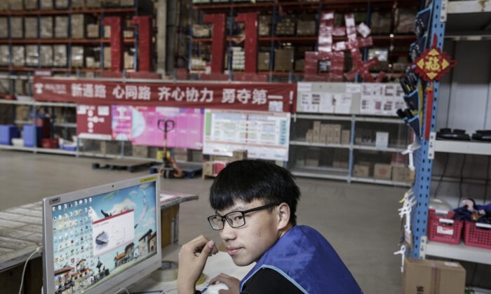 Работник использует компьютер для проверки посылок на складе логистической базы JingDong Group 5 ноября 2019 года в Ухане, провинция Хубэй, Китай. (Wang He/Getty Images) | Epoch Times Россия