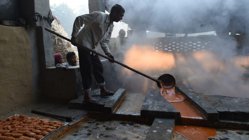Индийские рабочие готовят джаггери, традиционный тростниковый сахар, изготовленный из экстракта сока сахарного тростника, на заводе в Мураднагаре в индийском штате Уттар-Прадеш 19 ноября 2015 года. (Prakash Singh/AFP/Getty Images)  | Epoch Times Россия