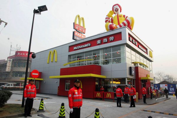 Китайский персонал ждёт первых клиентов в день открытия ресторана McDonald’s, построенного рядом с автозаправочной станцией в Пекине, 19 января 2007 года. (STR/AFP/Getty Images)
